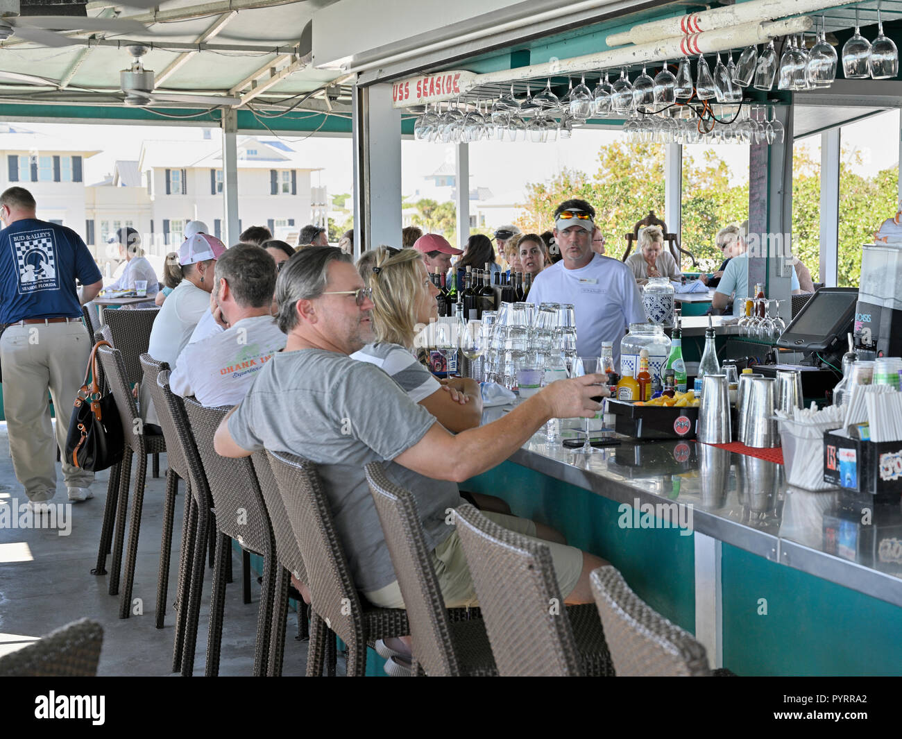 Barista maschio dietro il bar presso la trafficata bar sul tetto e ristorante grill o di Bud e vicolo della Florida Panhandle spiaggia cittadina di mare, STATI UNITI D'AMERICA. Foto Stock