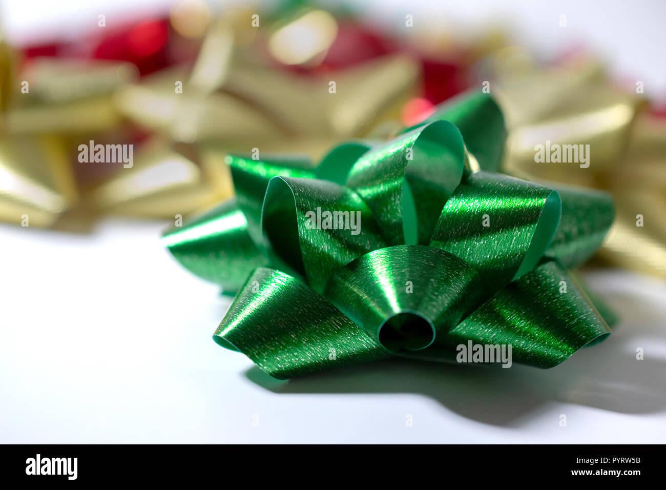 Vacanze di Natale nastro di raso archi. Verde, Oro, rosso. La luce sullo sfondo bianco. Camera per copia. Colori vividi. Foto Stock