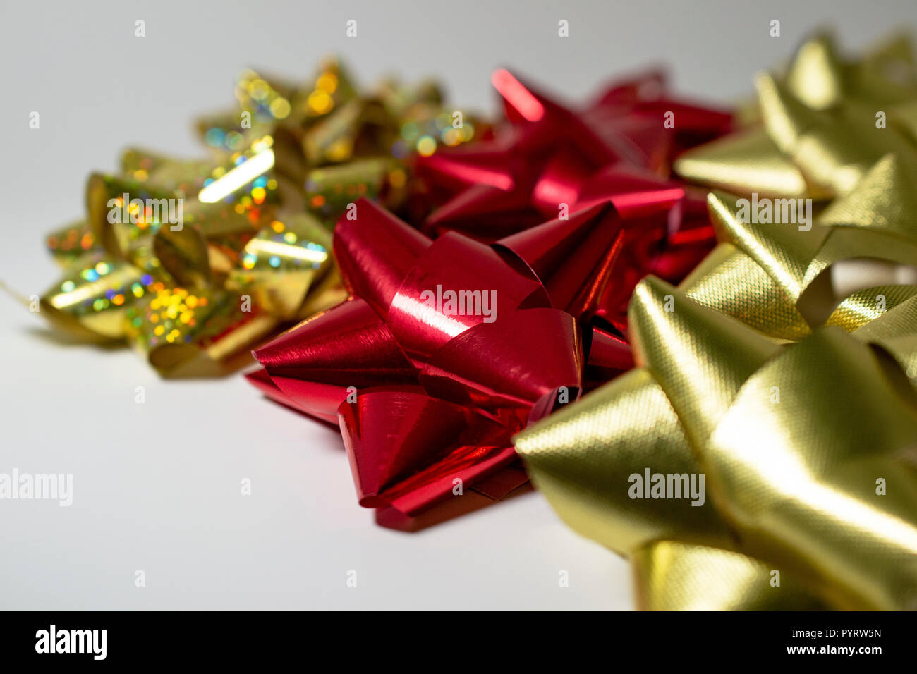 Vacanze di Natale in satin nastri. Rosso, oro satinato e Sparkle Dio. Sfondo chiaro. Camera per copia. Foto Stock