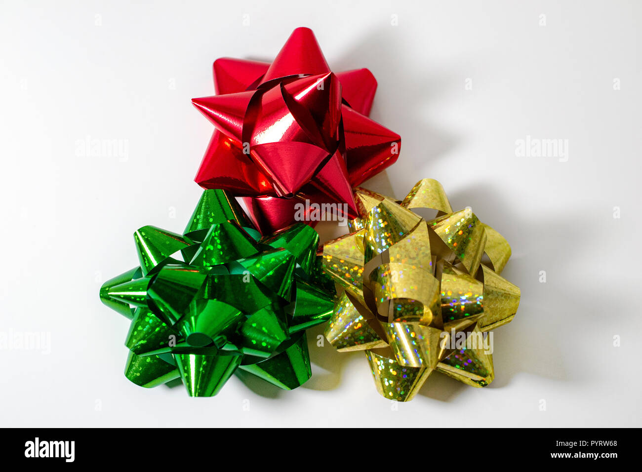 Vacanze di Natale nastro di raso fiocchetti, rosso, oro verde. Luce di sfondo bianco, camera per copia. Foto Stock