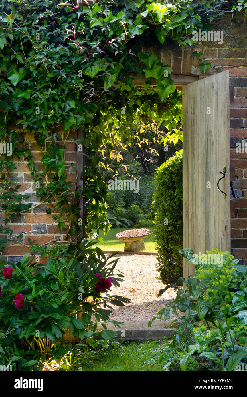 Porta in legno nella parete che conduce al Giardino Inglese,l'Inghilterra,l'Europa Foto Stock