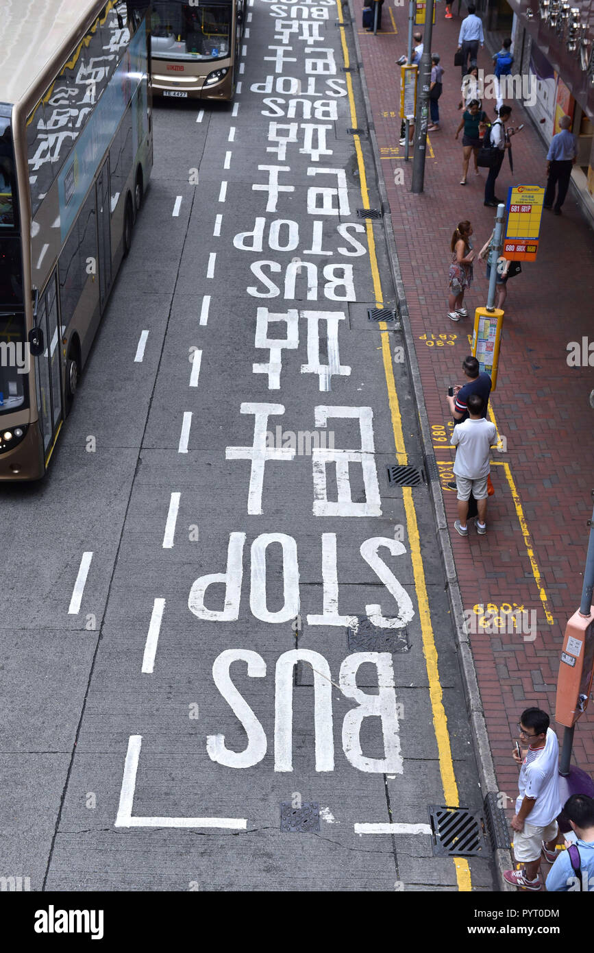 Cina: Hong Kong. Passeggeri ad una fermata di autobus e la segnaletica stradale Foto Stock