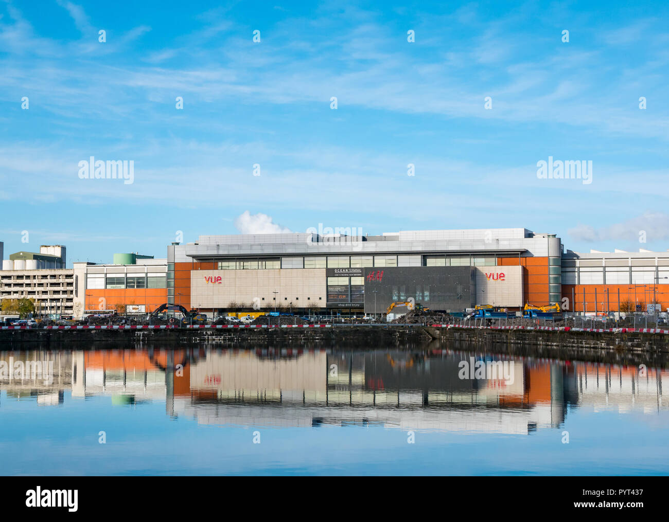 Vista di Ocean Terminal con H&M e logo Vue Cinema logo riflessi nell'acqua di Victoria dock in una giornata di sole, Leith, Edimburgo, Scozia, Regno Unito Foto Stock
