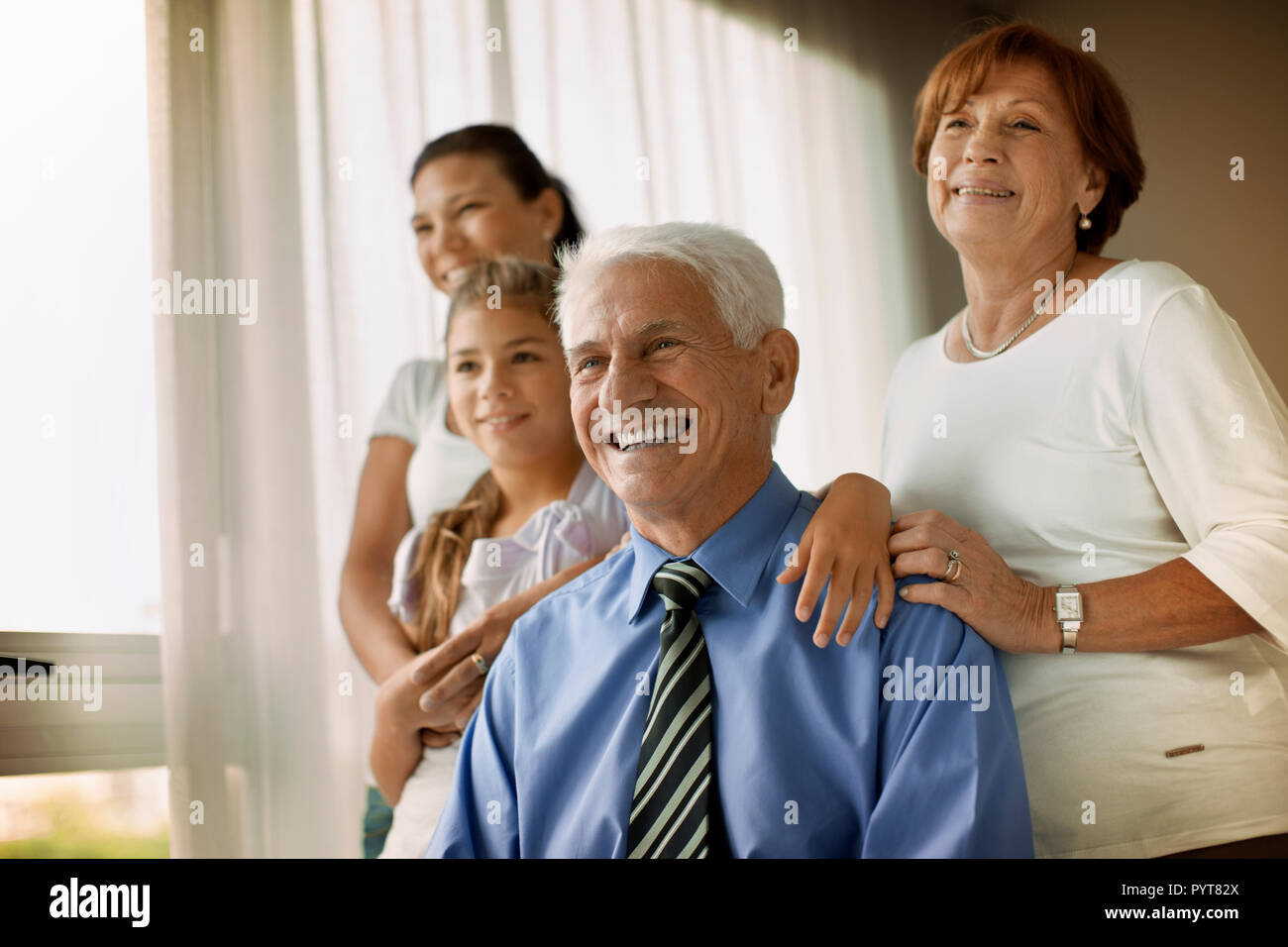 Sorridente uomo senior e alla sua famiglia un sorriso per un ritratto. Foto Stock