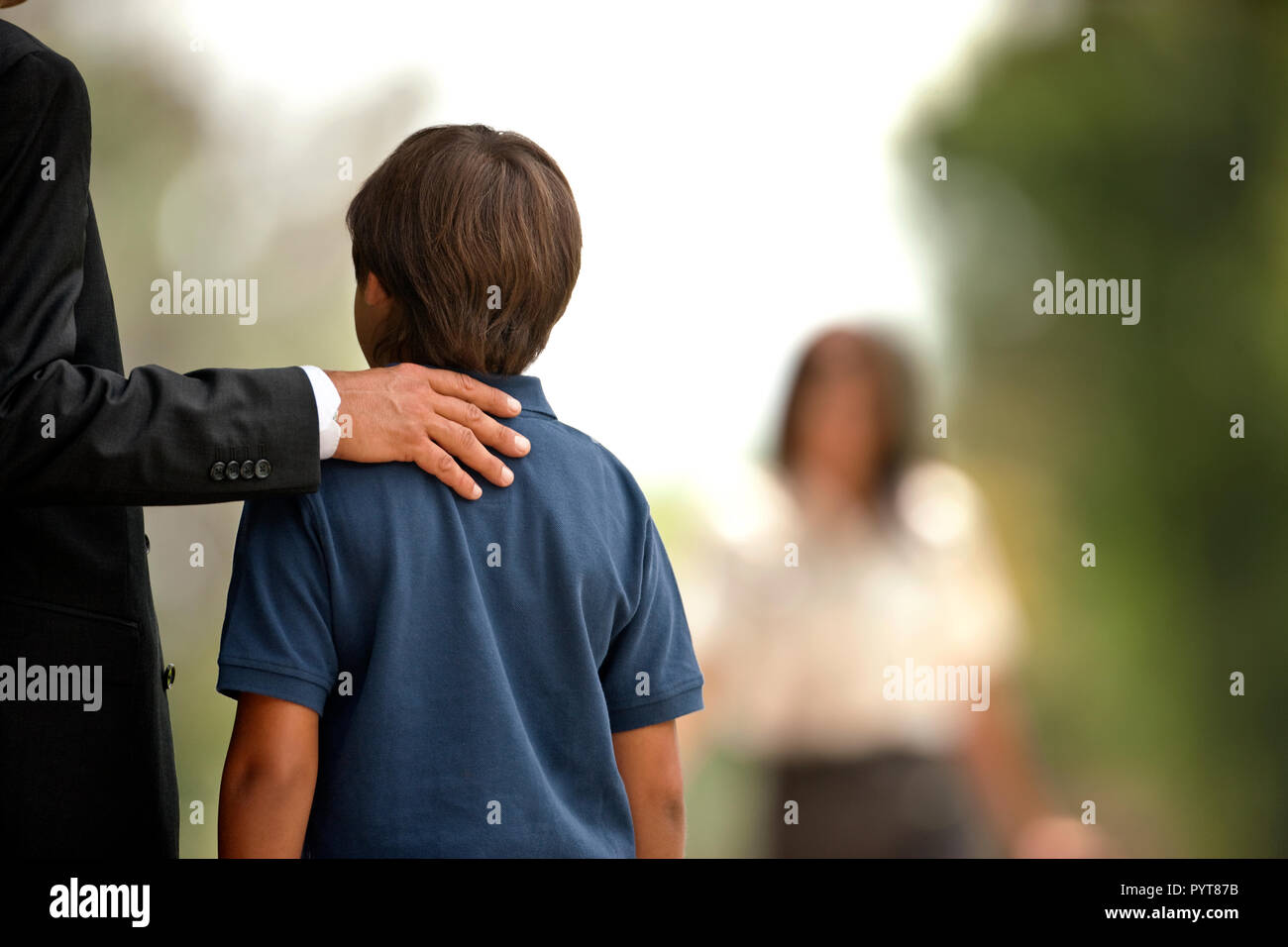Vista posteriore di un ragazzo in piedi accanto al suo papà. Foto Stock