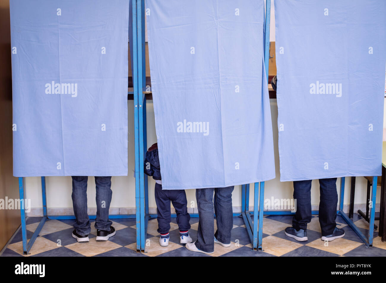 Immagine a colori di persone non identificabili voto in capanne in corrispondenza di una stazione di polling, durante le elezioni. Foto Stock