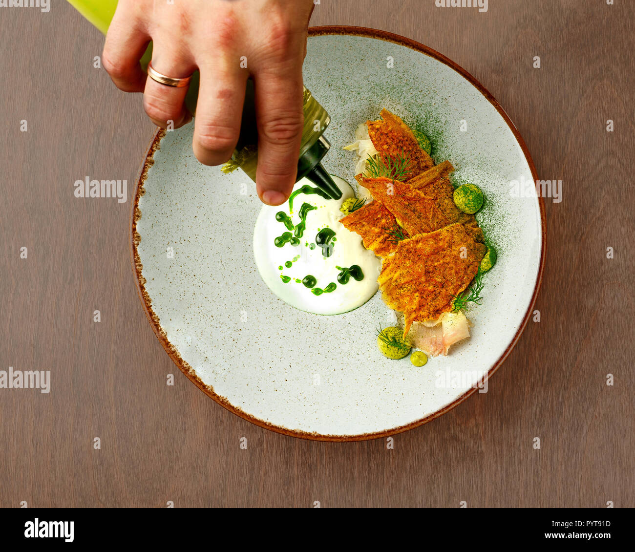 Tettuccio di colpo di pesce bianco chip di pane e olio verde Foto Stock