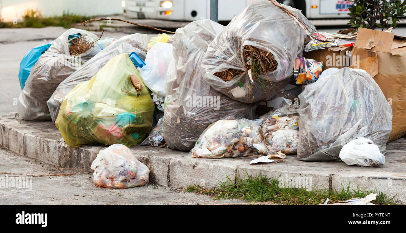 Sacchetti di rifiuti in strada sui marciapiedi. Foto Stock