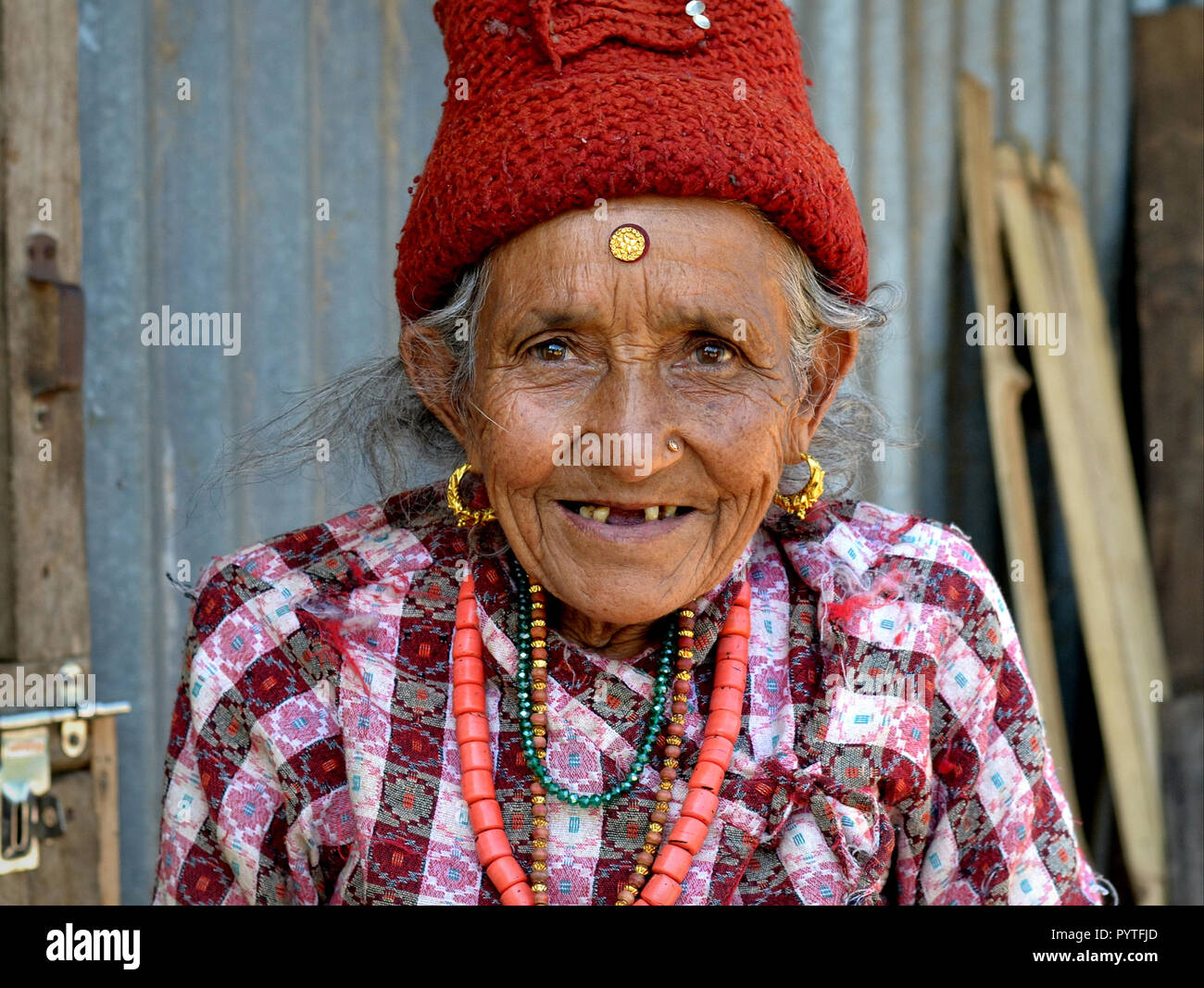 Molto vecchio Hyolmo nepalese donna con dente divario e una massiccia golden bindi sulla sua fronte. Foto Stock