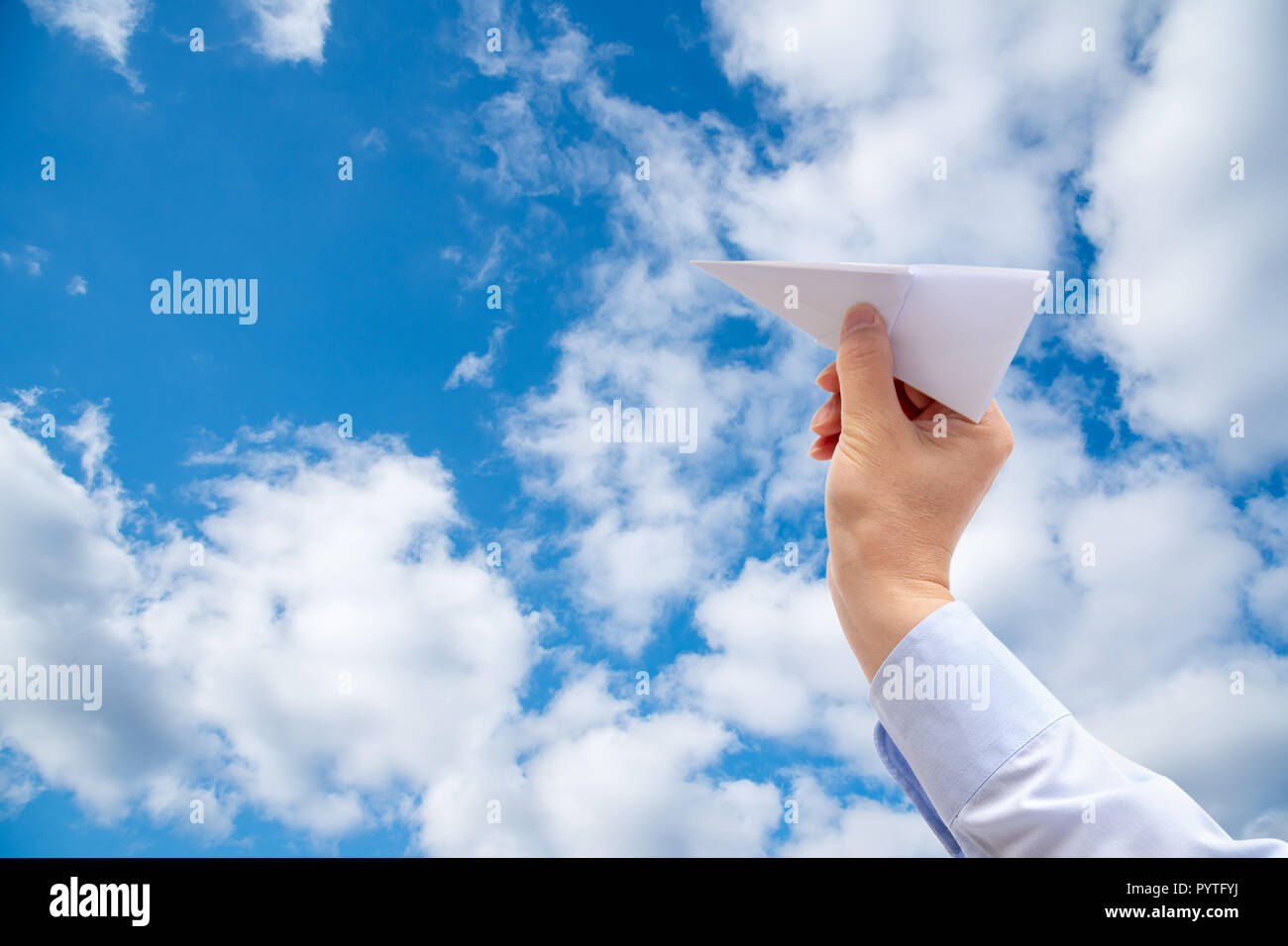 Imprenditore mano azienda aeroplano di carta sul cielo dello sfondo. Foto Stock