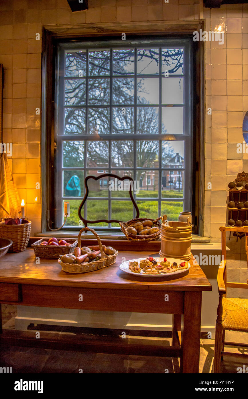 Storico di mobili da cucina in stile olandese antico edificio con la pasticceria e le verdure sul tavolo Foto Stock