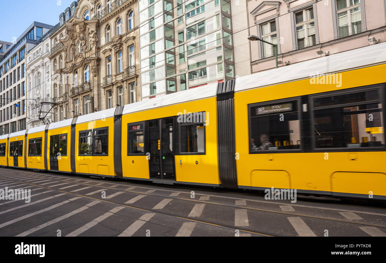 Tram giallo nel centro della città, edifici per uffici di sfondo, Berlino Foto Stock