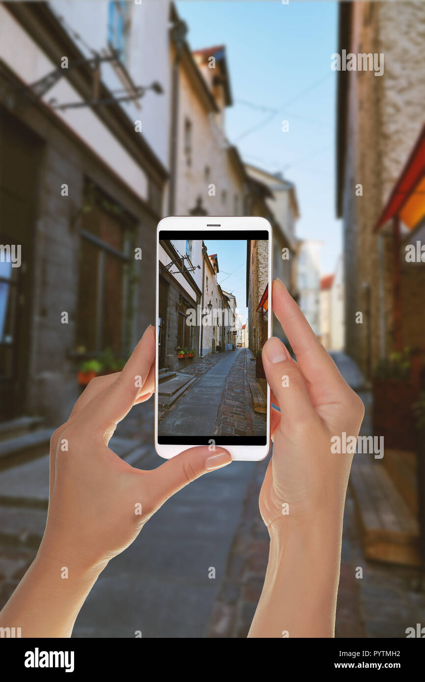 Un turista è di scattare una foto delle strade della città vecchia di Tallinn, Estonia senza persone su un telefono cellulare Foto Stock