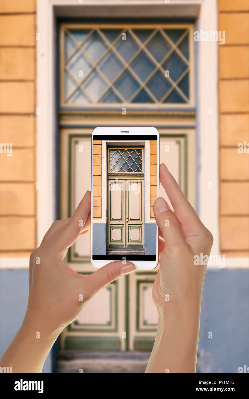 Un turista sta prendendo una foto del vecchio bella porta nella città vecchia di Tallinn, Estonia su un telefono cellulare Foto Stock
