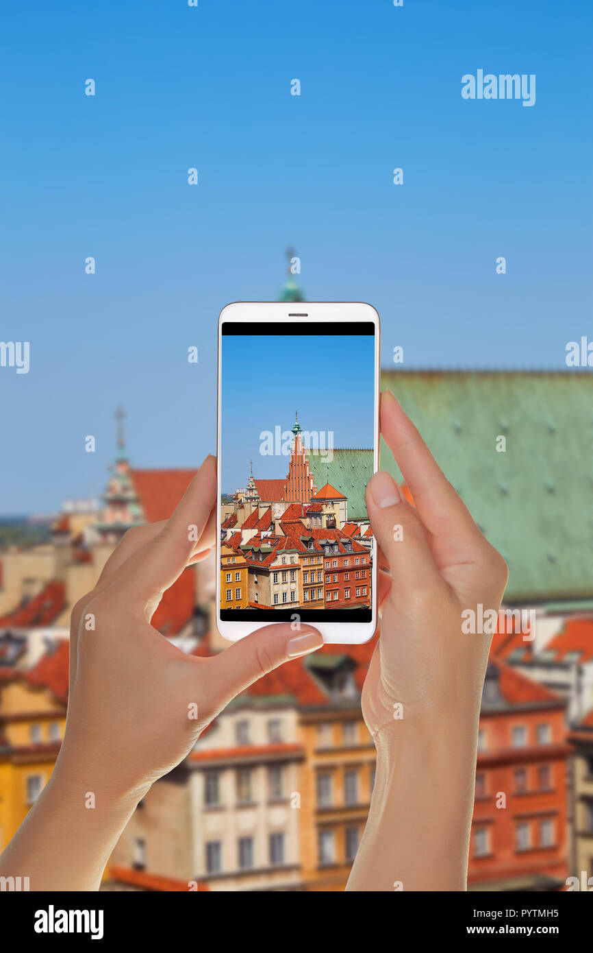 Un turista è scattare una foto della città vecchia a Varsavia su una soleggiata giornata estiva su un telefono cellulare Foto Stock