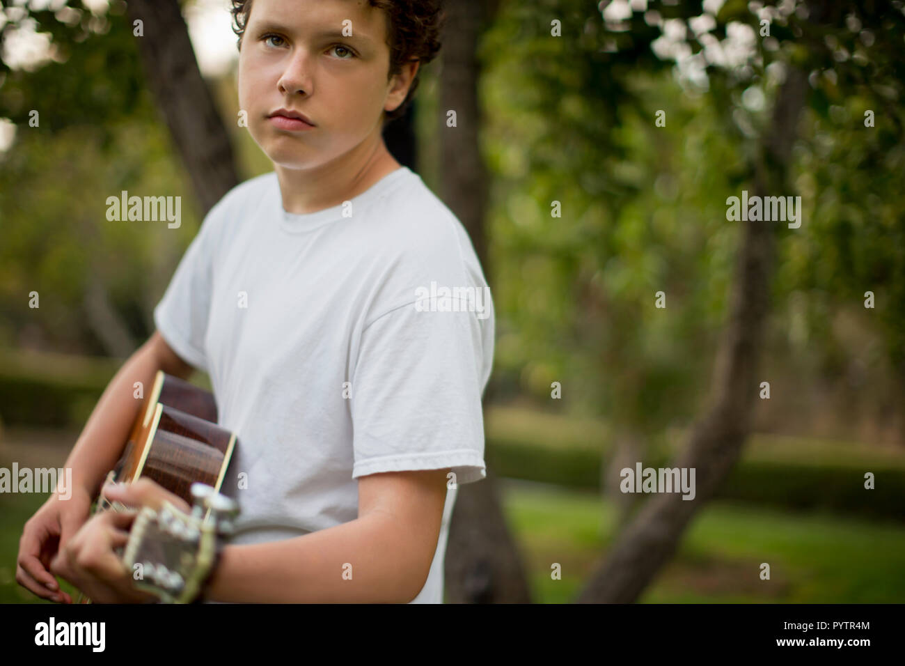 Ragazzo adolescente suonando una chitarra acustica. Foto Stock