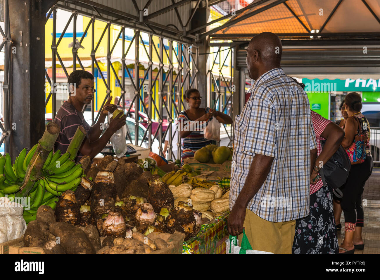 Fort-de-France, Martinica - 19 dicembre 2016: Locale uomo raccoglie le merci sul pittoresco di frutta e verdura del mercato coperto di Fort de France, il cappuccio Foto Stock