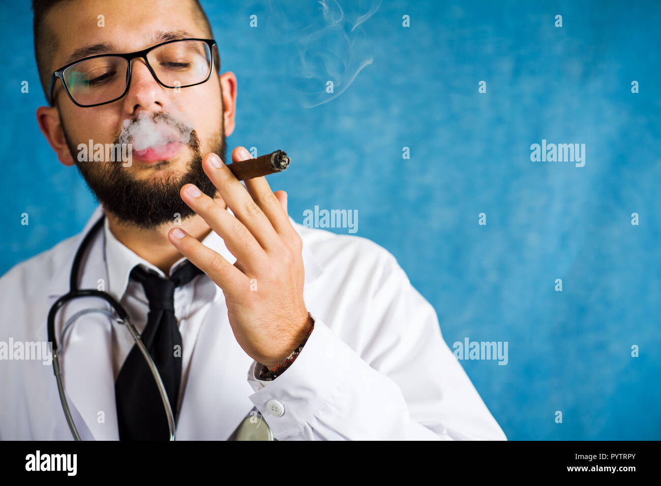 Medico di fumare una sigaretta e godendo di uno stile di vita poco salutare Foto Stock