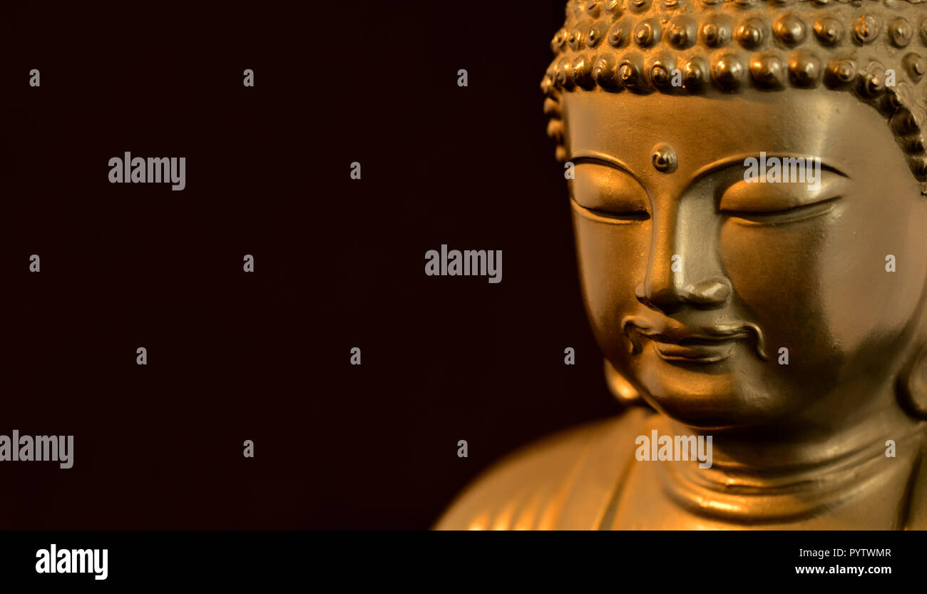 Golden BUDDA STATUETTA in atto di meditare (su sfondo nero con copia spazio) Foto Stock