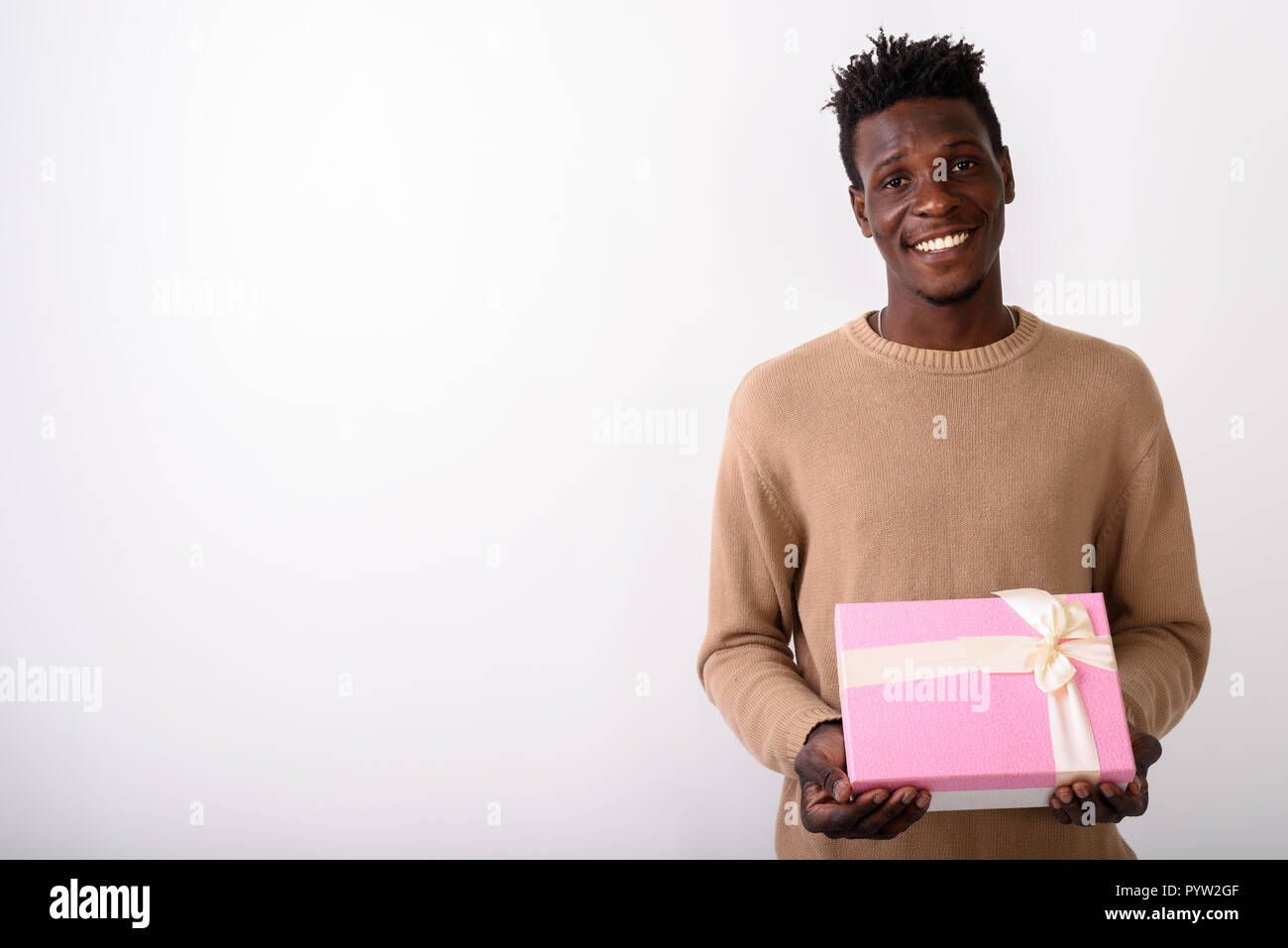 Studio shot di giovani felici Africano nero uomo sorridente mentre holdi Foto Stock