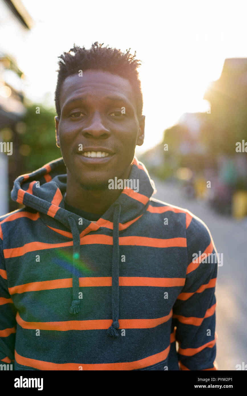 Ritratto di giovane felice slim Africano nero uomo sorridente all'aperto Foto Stock