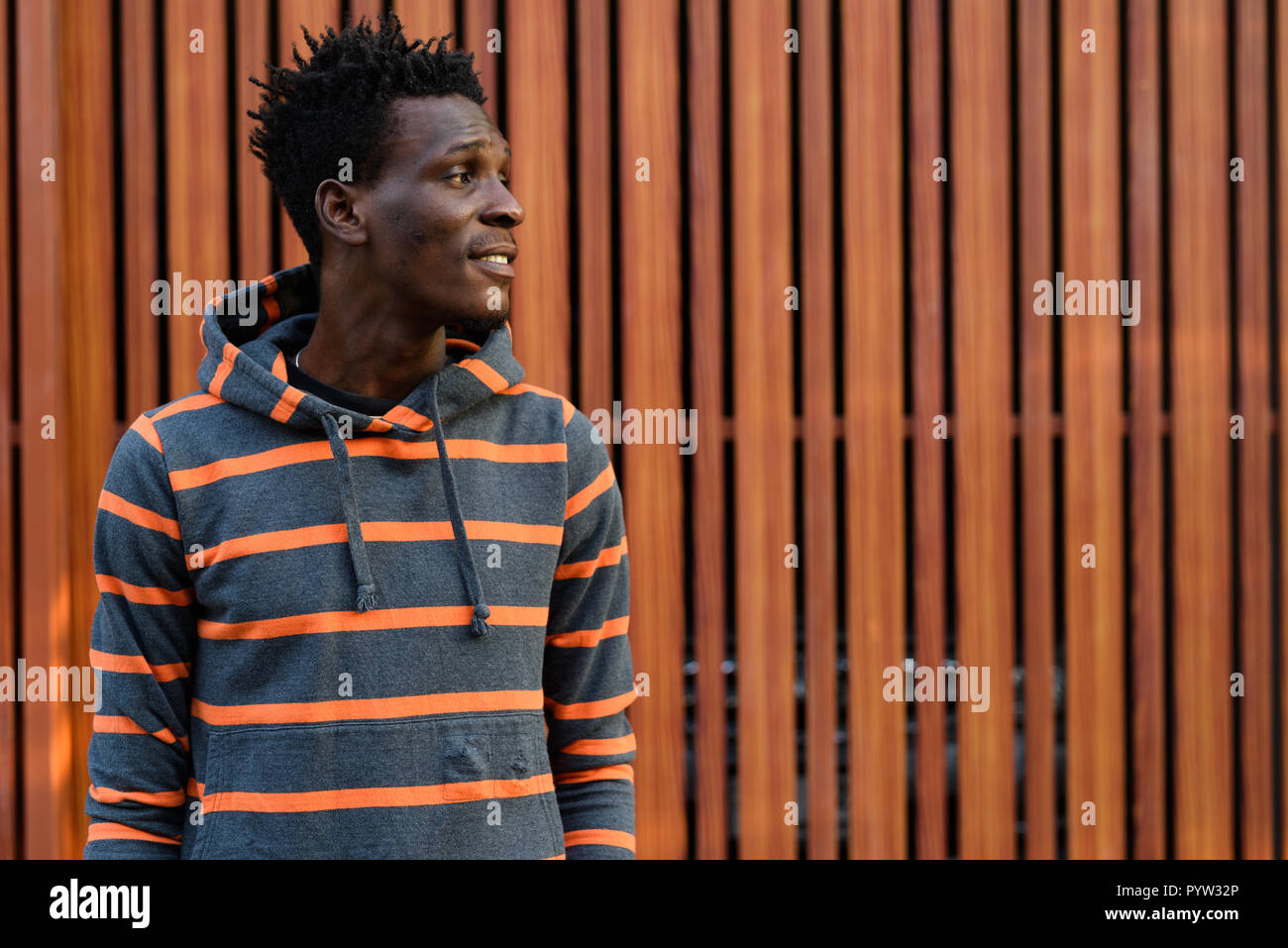 Vista di profilo di giovani felici Africano nero uomo sorridente mentre sottile Foto Stock