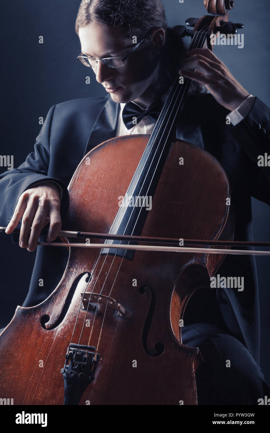 Il violoncellista riproduzione di musica classica in violoncello su sfondo nero Foto Stock