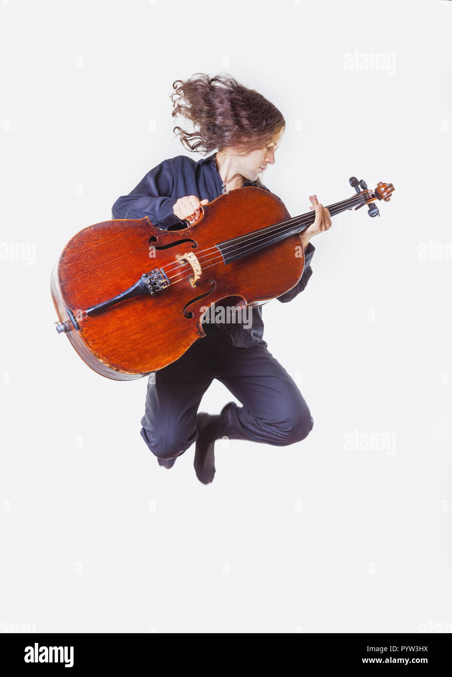 Il violoncellista con un violoncello nelle sue mani in un salto su sfondo bianco Foto Stock