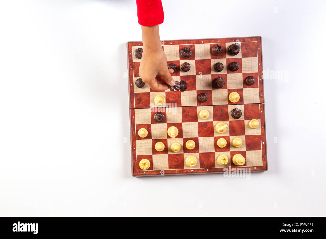 Il capretto con le mani su una scacchiera giocare a scacchi di gioco. Vista superiore Foto Stock