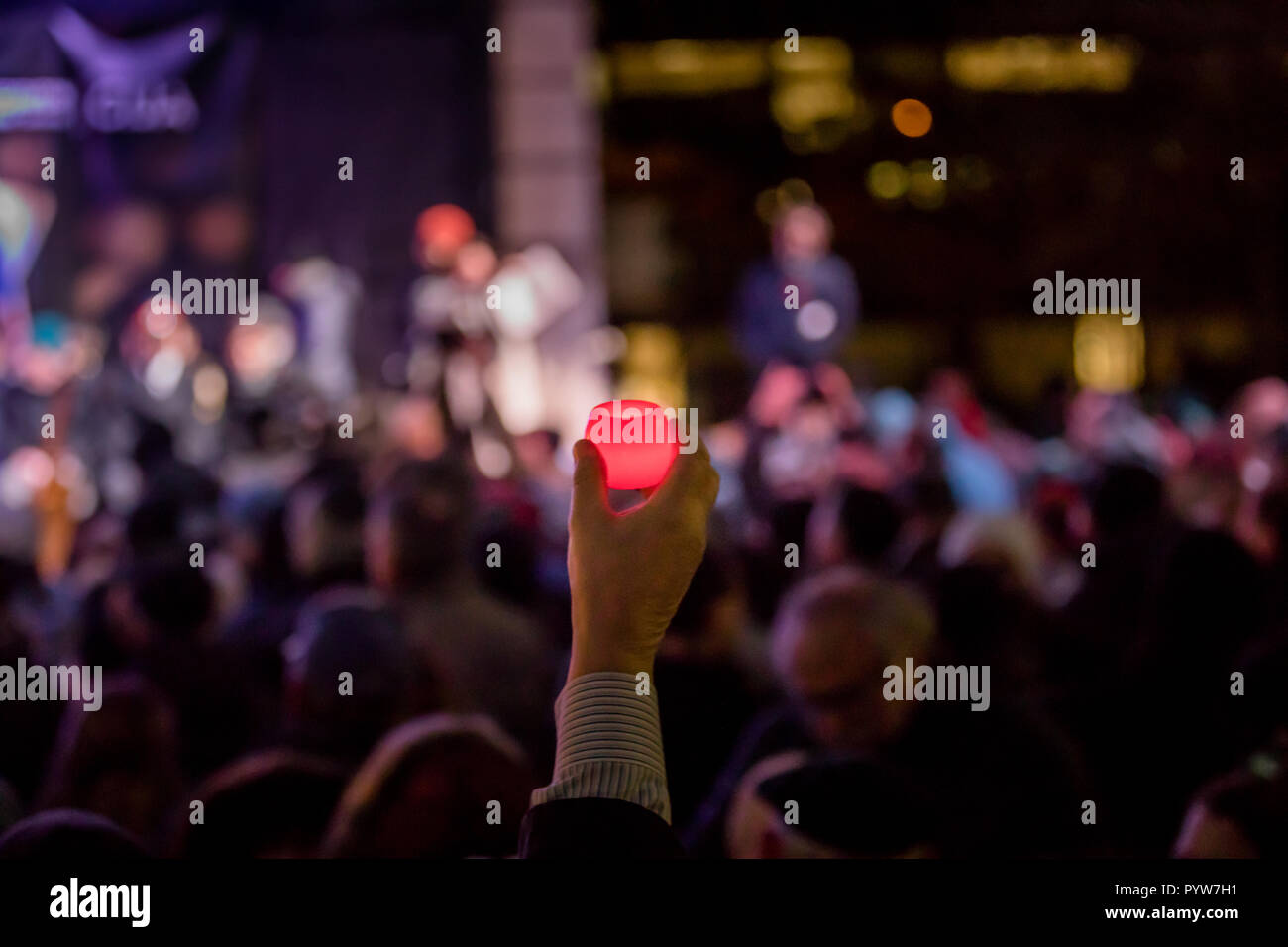 Toronto, Canada. 29 ottobre, 2018. Una mano può contenere fino a candela, con centinaia di persone intorno, durante una vigilia detenute da Toronto comunità ebraica per vittime della Sinagoga di Pittsburgh massacro a Mel Lastman Square, Credito: Shawn Goldberg/Alamy Live News Foto Stock