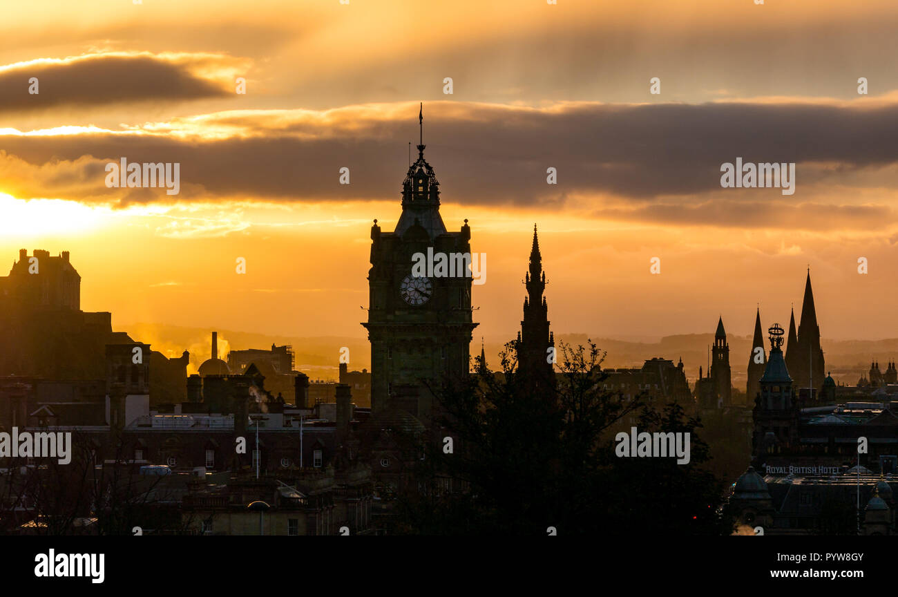 Edimburgo, Scozia, Regno Unito, 30/10/2018. Regno Unito Meteo: arancione tramonto nel centro della città con il distintivo contorni di Edimburgo di edifici e monumenti tra cui il Balmoral Hotel Clock Tower, il Monumento di Scott e il Castello di Edimburgo visto da di Calton Hill Foto Stock