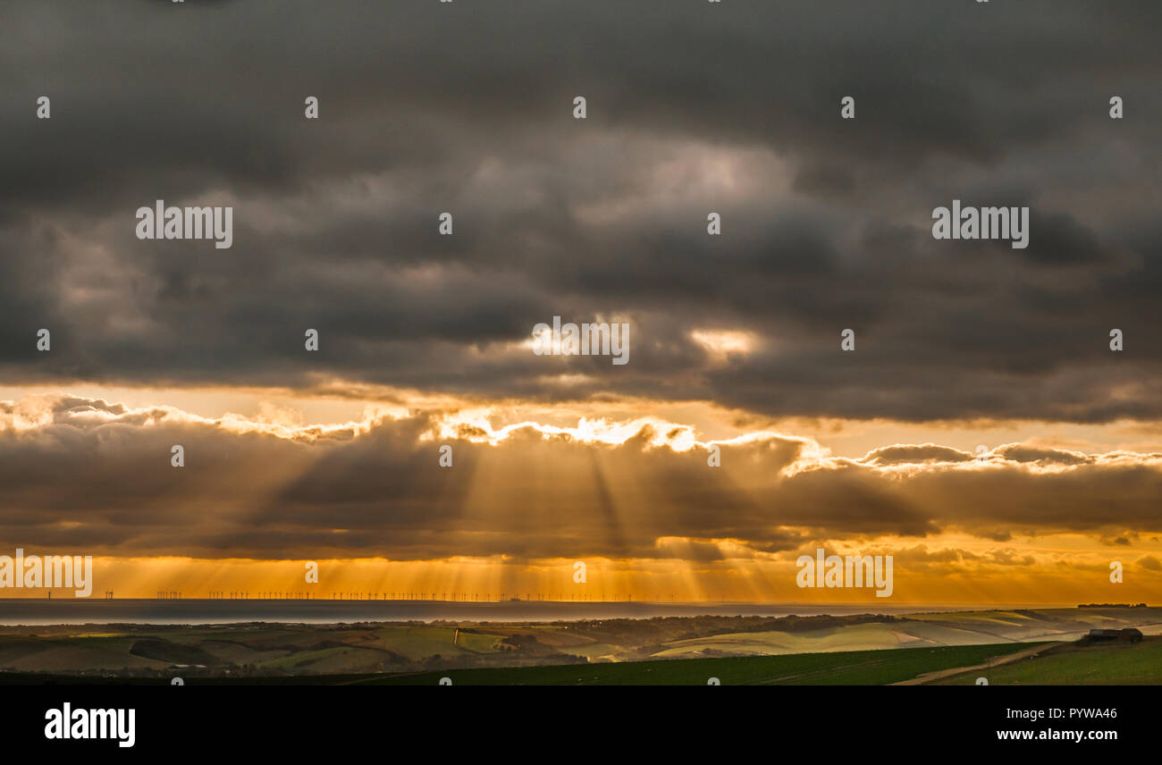 Firle, Lewes, East Sussex, Regno Unito. 30 ottobre 2018..Vista da Firle Beacon nei Downs del sud che si affaccia sulla centrale eolica offshore Seaford & Rampion, mentre il sole si rompe attraverso la copertura cloud poco prima del tramonto. Molto più freddo ora con una brezza rigida dal Nord Est. Foto Stock