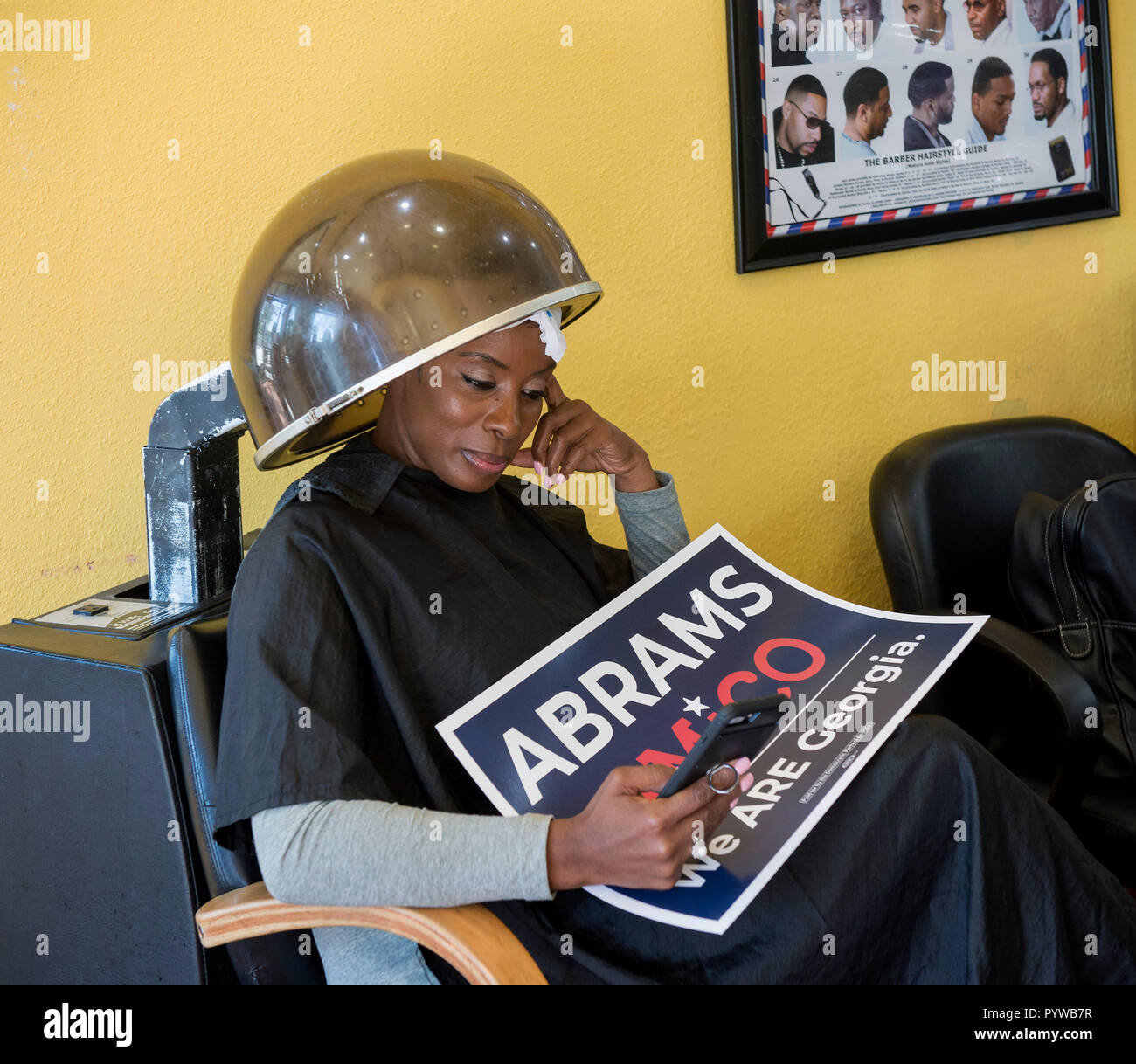 Atlanta, Georgia, Stati Uniti d'America. 30 ott 2018. Aprile Mason si siede sotto un asciugacapelli in attesa per il candidato democratico per la Georgia governatore, STACEY Abrams, di tenere una votazione anticipata al rally fino il prossimo salone di parrucchiere e barbiere. Credito: Brian Cahn/ZUMA filo/Alamy Live News Foto Stock