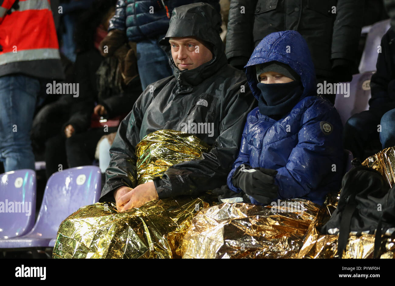 Il 30 ottobre 2018, Bassa Sassonia, Osnabrück: Calcio: DFB Cup, 2° round, SV Rödinghausen - FC Bayern Monaco di Baviera nello stadio di Bremer Brücke. Gli spettatori hanno un blanket di emergenza realizzato da una lamina metallica giacente su di loro giri. Foto: Friso Gentsch/dpa - WICHTIGER HINWEIS: Gemäß den Vorgaben des DFB Deutscher Fußball-Bund ist es untersagt, in dem Stadion und/oder vom Spiel angefertigte Fotoaufnahmen in forma von Sequenzbildern und/oder videoähnlichen Fotostrecken zu verwerten bzw. verwerten zu lassen. Foto Stock