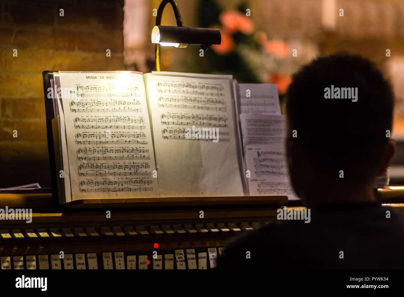 Retro del pianista guardando il punteggio sul organo da chiesa Foto Stock