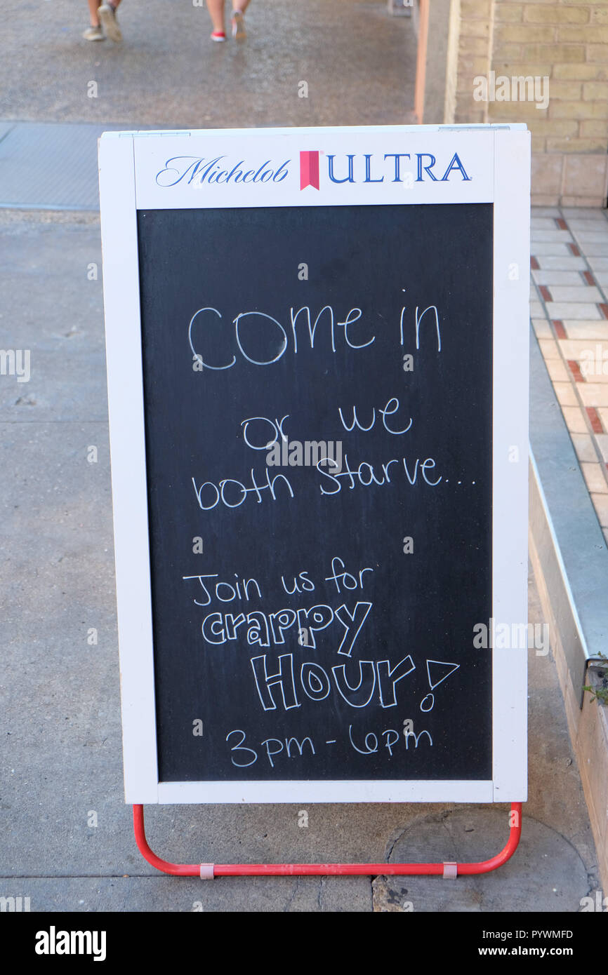 Cartello esterno ristorante invitante patroni di " Vieni in o entrambi abbiamo fame"; happy hour; San Antonio, Texas, Stati Uniti d'America. Foto Stock