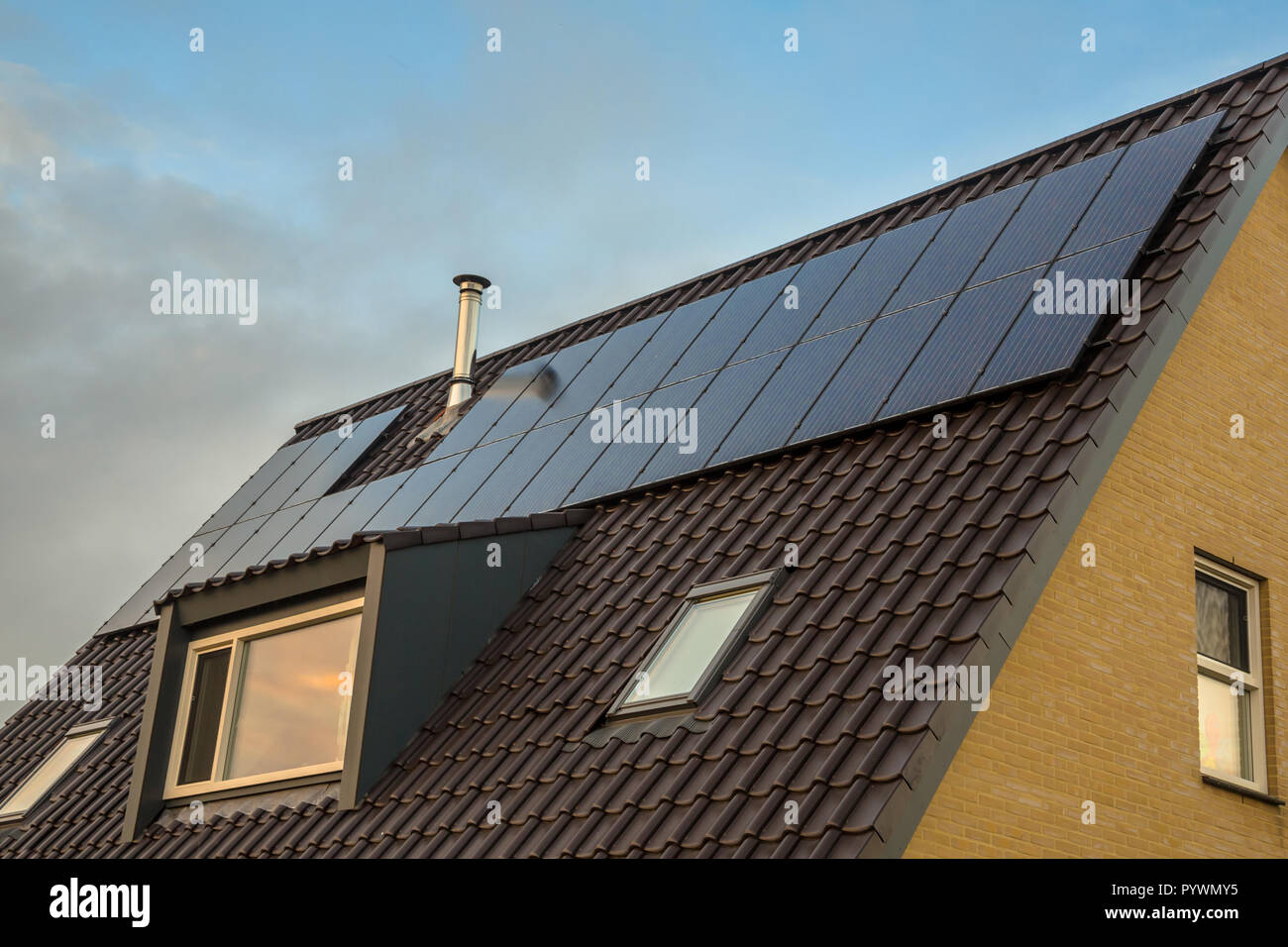 Discreto pannelli solari nello stesso colore come tegole del tetto e abbaino su una casa Foto Stock