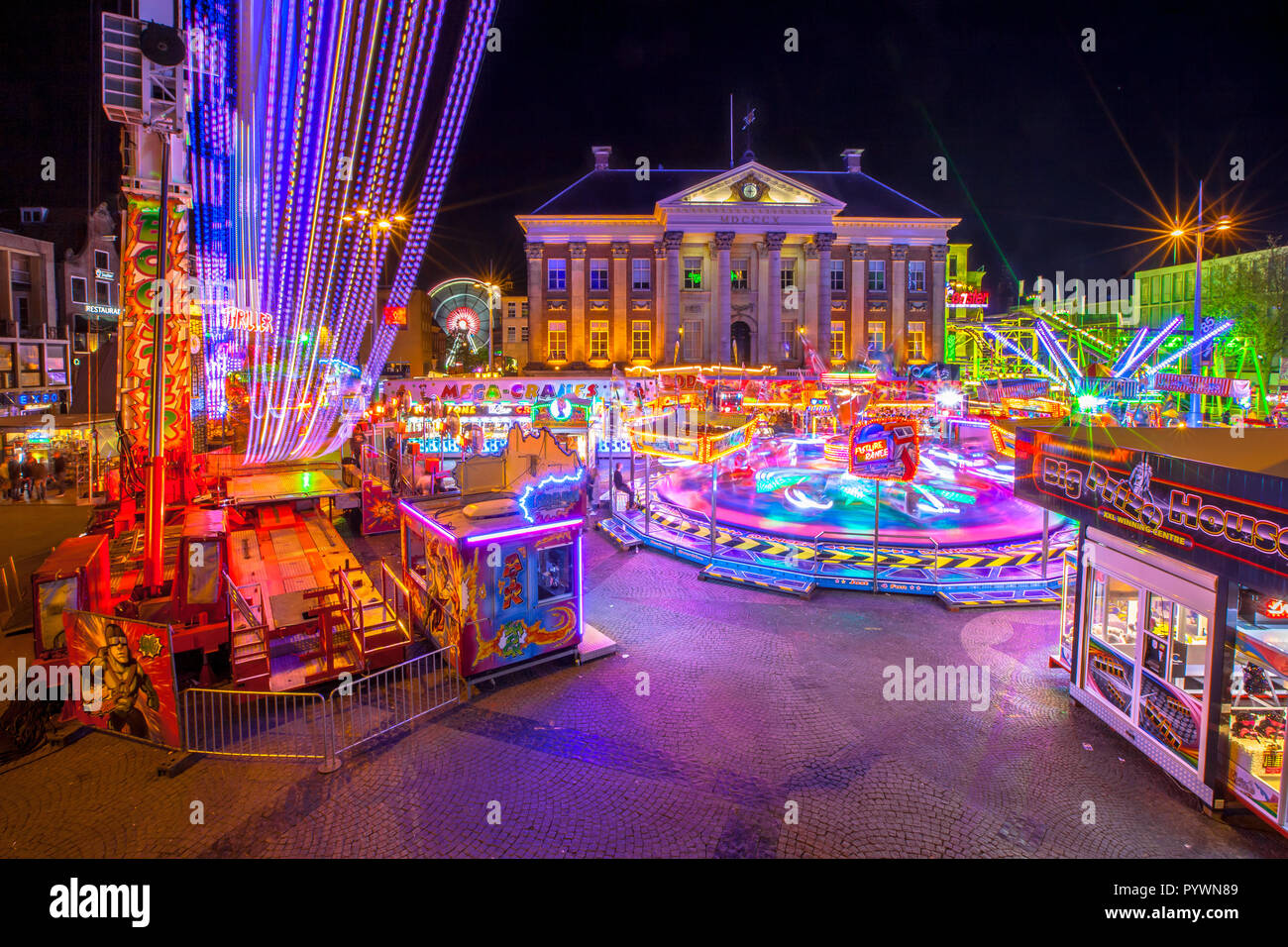 GRONINGEN, PAESI BASSI-MAGGIO 5,2015: Annuale Luna Park durante la vacanze di maggio sul Grote Markt cenral city square. Lunga immagine di esposizione di notte con blu Foto Stock