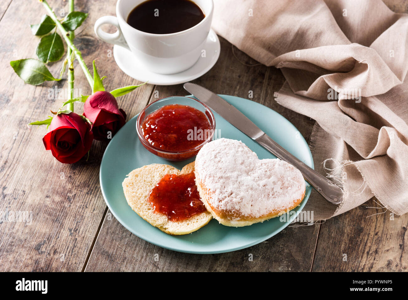 Il giorno di San Valentino la prima colazione con caffè, a forma di cuore bun e marmellata di frutti di bosco. Foto Stock