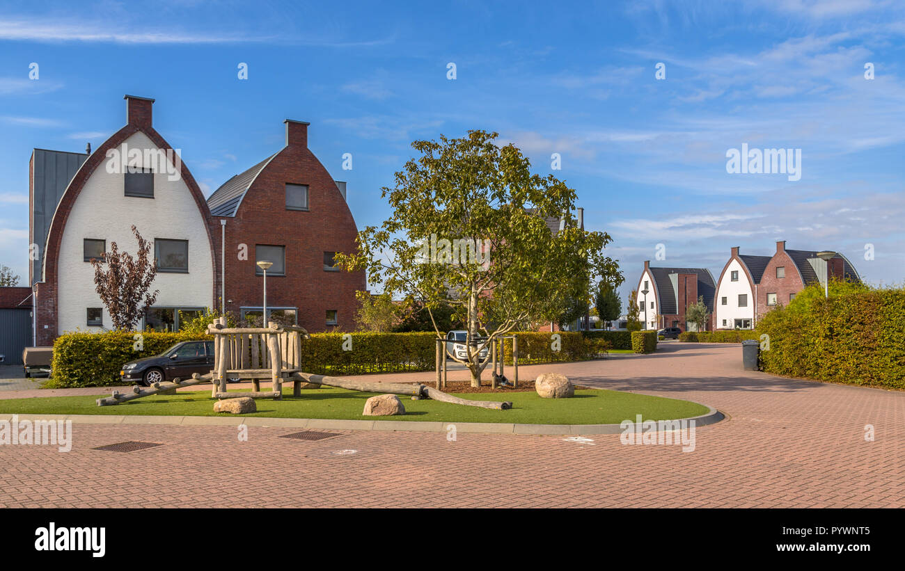 Conspicious suburbane moderne case di famiglia in un bambino-friendly neighborhood con alberi e parco giochi Foto Stock