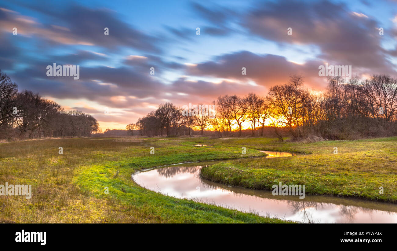 Creek con nuvole offuscata dalla lunga esposizione come metafora per il cammino spirituale e di esplorazione personale. Foto Stock