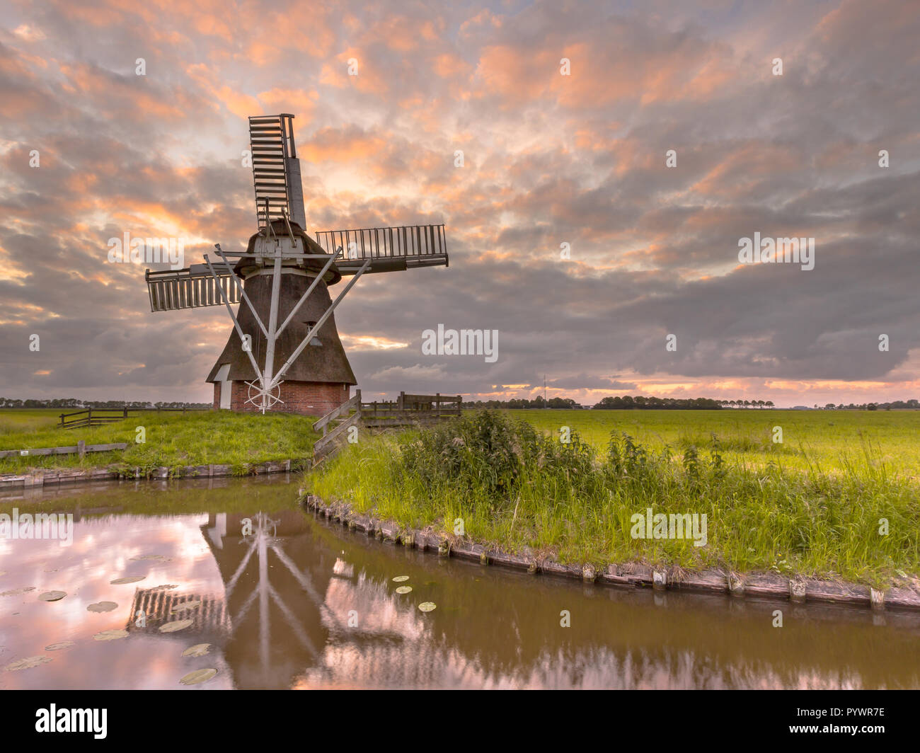 Legno storico Mulino a vento nel paesaggio di polder nei Paesi Bassi. In passato questi edifici utilizzati per giocare un ruolo nella gestione delle acque della countr Foto Stock