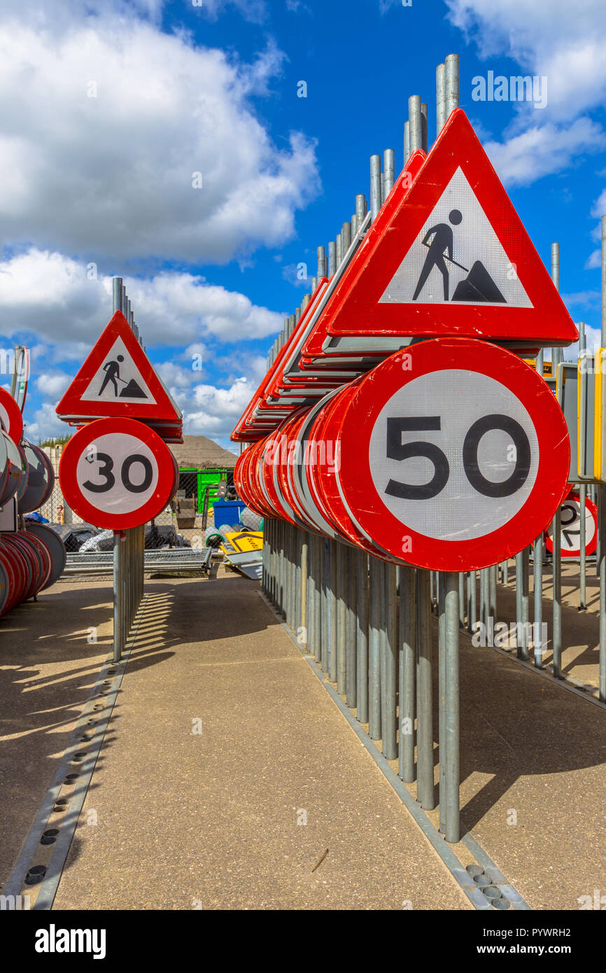 Lavori in corso il limite massimo di velocità segni tra altre righe di segni di traffico in attesa di essere ingaggiato in progetti di costruzione stradale Foto Stock