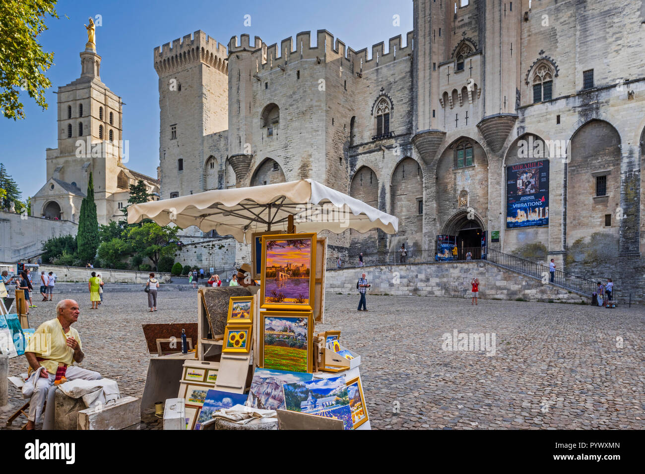 Artista vendere dipinti di fronte al Palais des Papes / Palazzo dei Papi della Città Avignon Vaucluse, Provence-Alpes-Côte d'Azur, in Francia Foto Stock