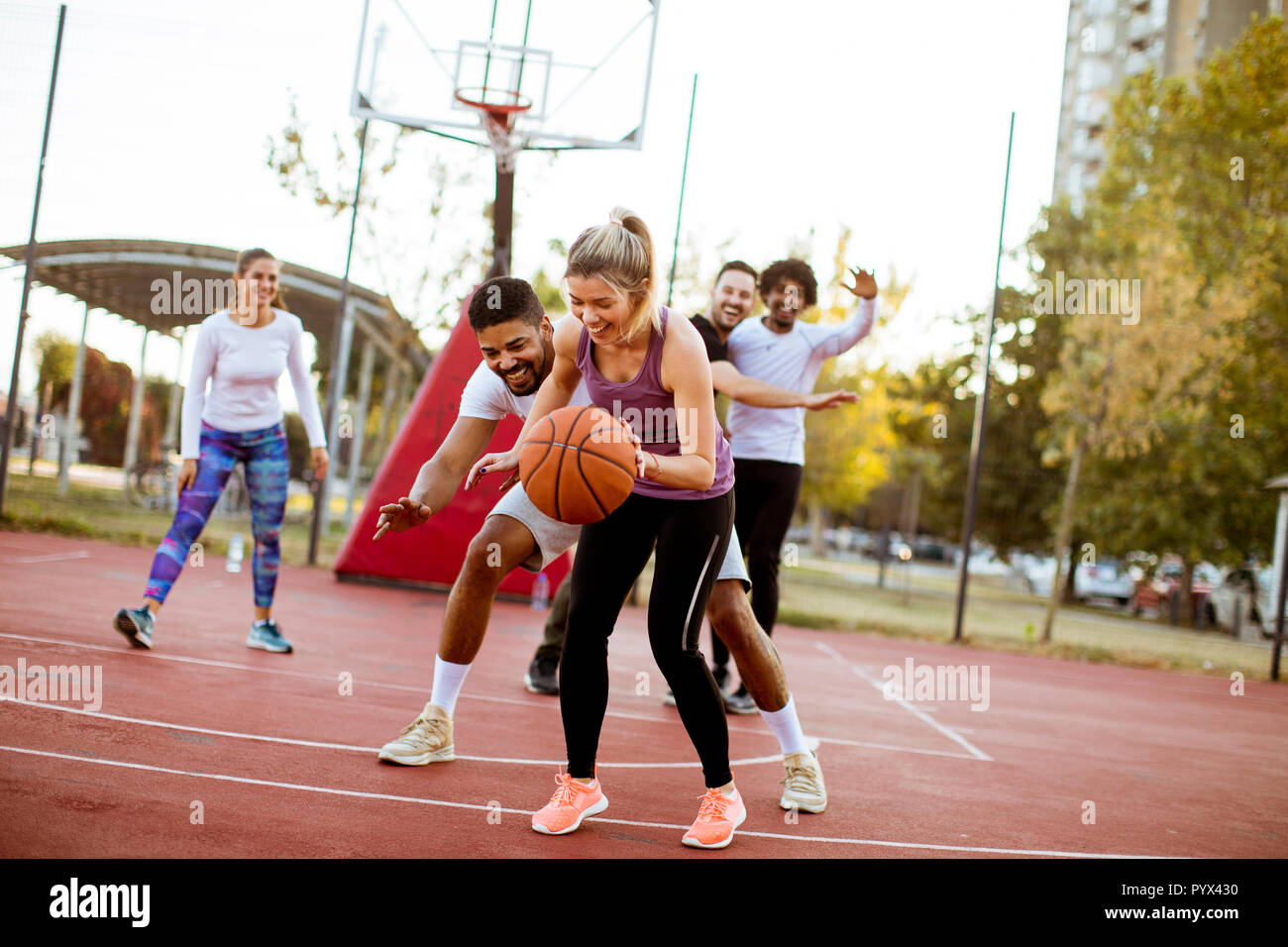 Gruppo di multirazziale giovani giocatori di basket sulla corte a all'aperto Foto Stock