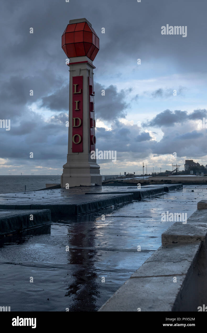 L'Art Deco Lido signpost sul lungomare in Margate. In una buia sera piovosa nelle pozzanghere sul tetto del lido riflettono il segno. Anche in B&W. Foto Stock