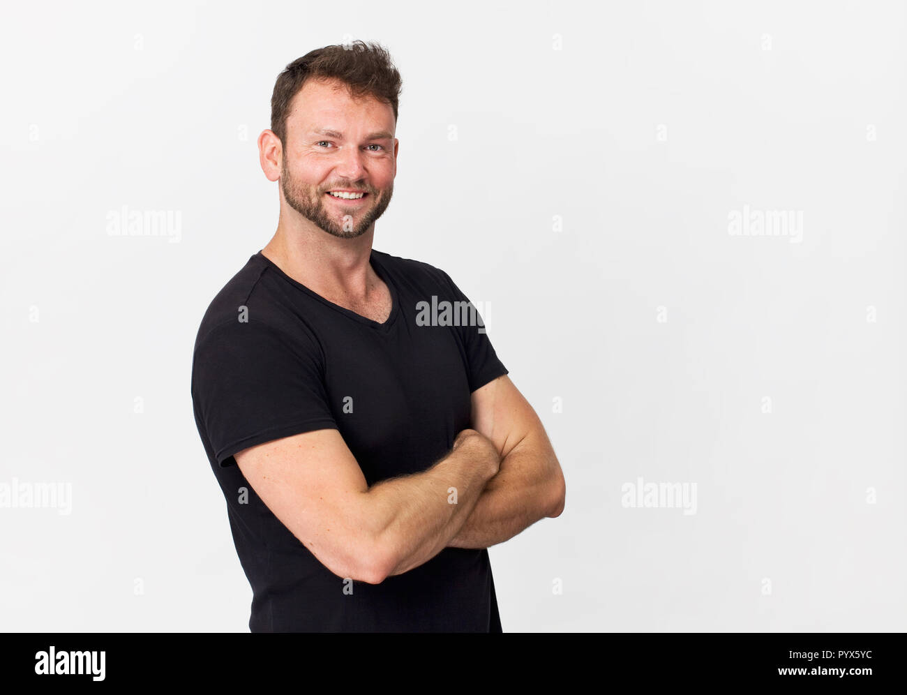 Felice, bel giovane uomo in nero ritratto sorridente contro uno sfondo bianco Foto Stock