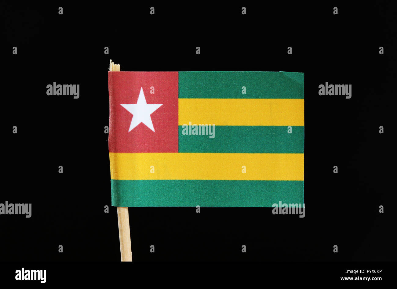 Un ufficiale e originale di bandiera del Togo su stuzzicadenti su sfondo nero. Esso dispone di cinque bande di colore verde alternato con il giallo e il campo rosso con stella. Foto Stock