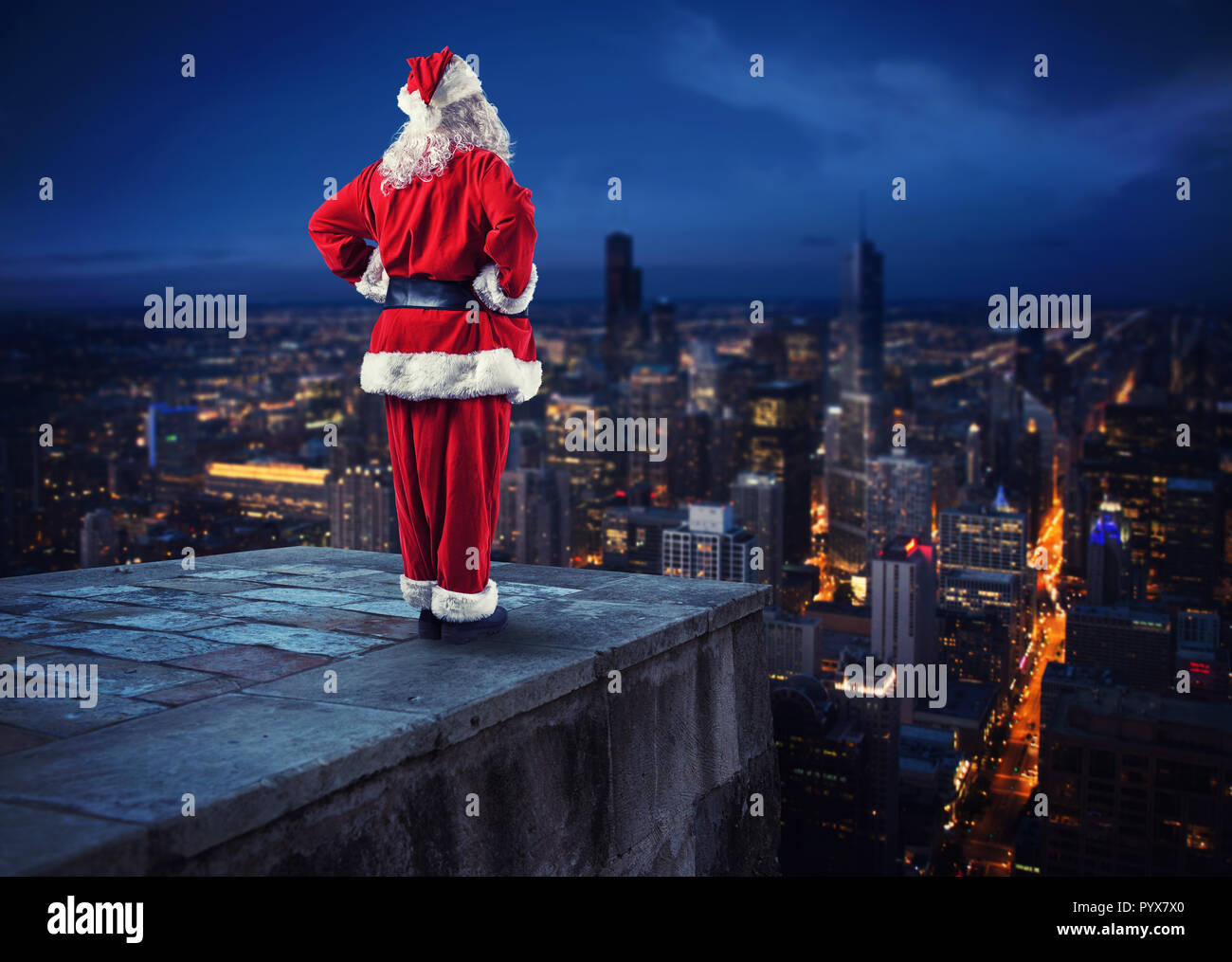 Babbo Natale guarda giù sulla città in attesa di consegnare i regali Foto Stock