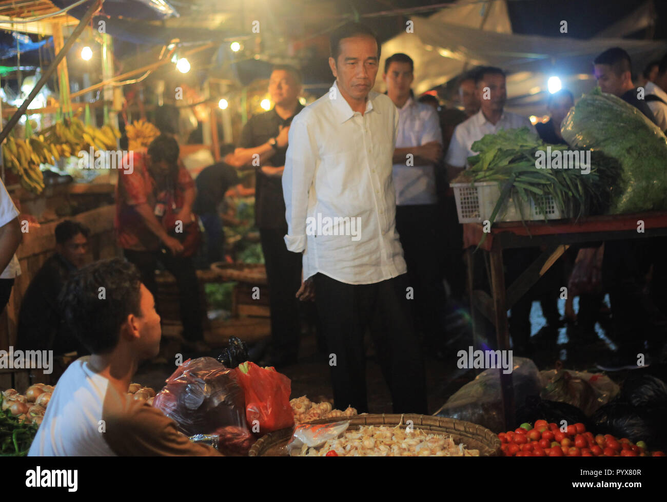 Presidente di Joko Widodo (C) visto durante la sua visita al tradizionale mercato di Bogor città. Presidente di Joko Widodo mentre si parla con i commercianti ha chiesto loro circa i prezzi che vendono le loro merci. Il Presidente ha sottolineato che il prezzo delle merci di pinzatura è stabile. Foto Stock